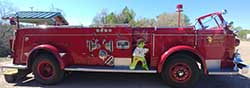 Timmy hops a ride on Smokey the Bear's fire truck